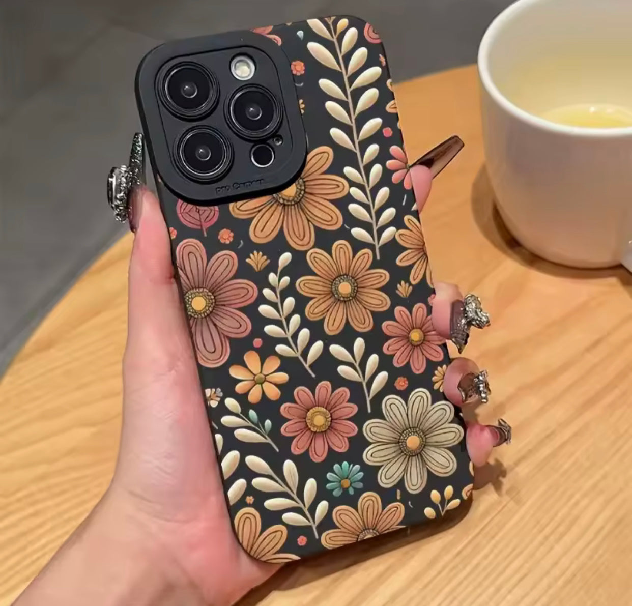 غطاء هاتف آيفون ناعم الملمس بتصميم زهرة الأقحوان على خلفية سوداء